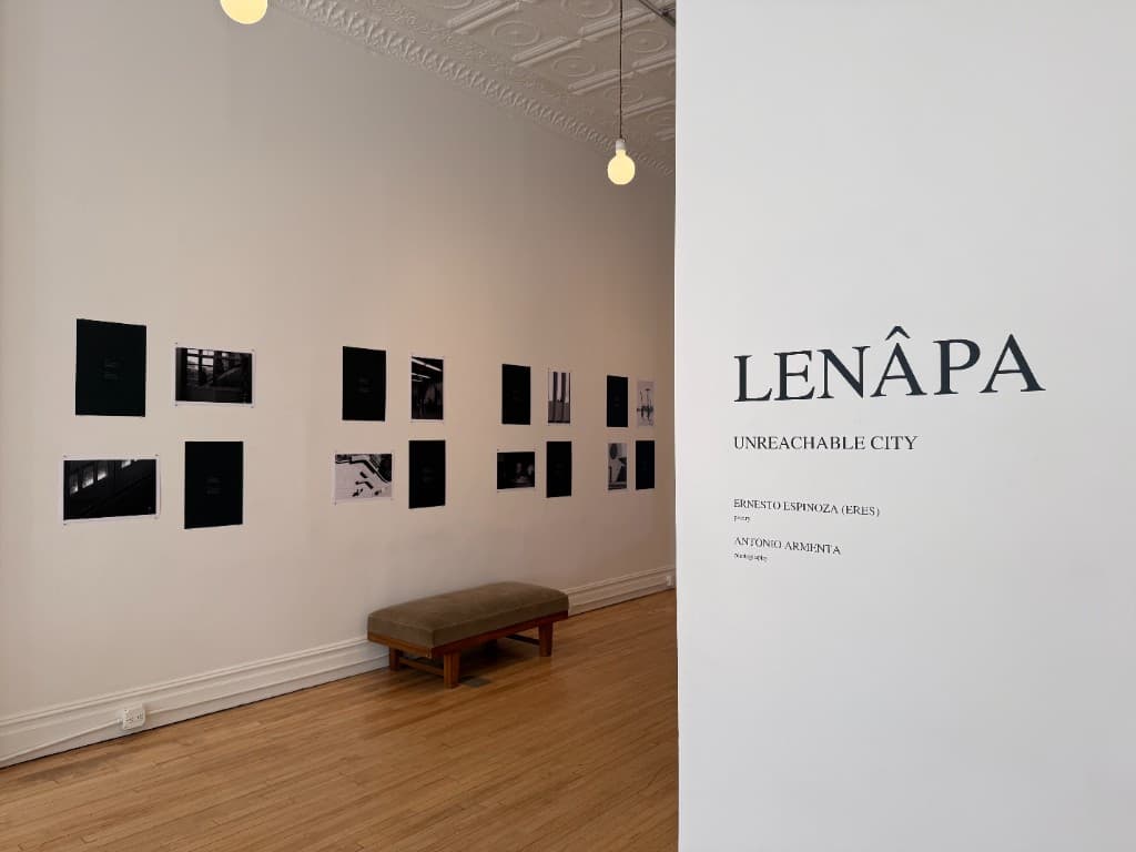 Two collaborators installing Lenâpa works on a gallery wall.
